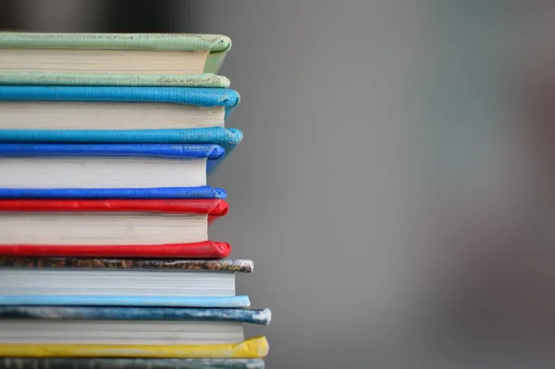 Row of study notebooks and books on a desk